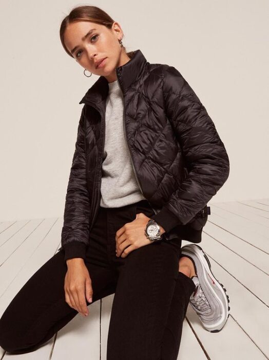 Outfit elegante casual con jeans negro y campera inflada puffer negra