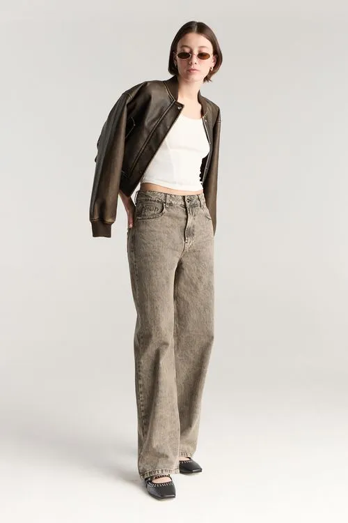 campera de cuero marron oscuro y jeans grises DESIDERATA